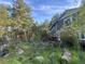 Beautiful green home nestled among rocks and trees with peek of red deck at 4574 Picutis Rd, Indian Hills, CO 80454