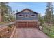 Two-story home with a blue siding and stone accents, and a two-car garage at 4574 Picutis Rd, Indian Hills, CO 80454