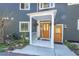Charming front porch with colorful hanging flowers and a decorative front door at 4574 Picutis Rd, Indian Hills, CO 80454