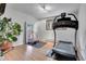 Bright home gym with a treadmill, large mirror, and a potted plant creating a fitness-focused space at 4574 Picutis Rd, Indian Hills, CO 80454