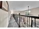 Upstairs hallway with carpeting and wrought iron banister overlooking a large living room at 4574 Picutis Rd, Indian Hills, CO 80454