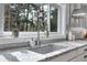 Kitchen sink area with stainless steel faucet, granite countertop and backyard view at 4574 Picutis Rd, Indian Hills, CO 80454