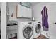 Functional laundry room with washer, dryer, utility sink, and overhead storage cabinets at 4574 Picutis Rd, Indian Hills, CO 80454