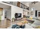 Bright living room with high ceilings, wood floors, and staircase to loft area at 4574 Picutis Rd, Indian Hills, CO 80454