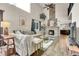 Bright living room featuring a stone fireplace, ceiling fan, and hardwood floors at 4574 Picutis Rd, Indian Hills, CO 80454