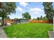 Large backyard with a privacy fence, new shed, mature trees, and lush green grass at 1440 S Clermont St, Denver, CO 80222