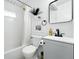 Clean bathroom with white tiles, a shower with a curtain, and black hardware at 1440 S Clermont St, Denver, CO 80222