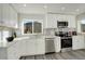 Modern kitchen boasts stainless steel appliances, stone countertops, and decorative tile backsplash at 4835 Grove St, Denver, CO 80221