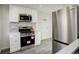 Contemporary kitchen featuring stainless steel appliances, white cabinets, and stylish backsplash at 4835 Grove St, Denver, CO 80221
