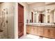 Elegant bathroom with a glass-enclosed shower, wood cabinets, granite countertop and large mirror, offering a spa-like experience at 4041 E Forbes Ct, Greenwood Village, CO 80121