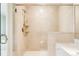 Bright bathroom featuring a glass door, neutral-toned tiling, a built-in bench, and modern shower fixtures at 4041 E Forbes Ct, Greenwood Village, CO 80121