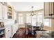 Bright breakfast nook with an adjacent kitchen, a large bay window, hardwood flooring, and custom cabinets at 4041 E Forbes Ct, Greenwood Village, CO 80121