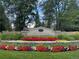 Community entrance featuring a beautiful floral arrangement, lush trees, and clear blue skies, giving the area a welcoming feel at 4041 E Forbes Ct, Greenwood Village, CO 80121