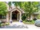 Covered front entrance with stone pillars, manicured landscaping, and elegant lighting fixtures creating a welcoming approach at 4041 E Forbes Ct, Greenwood Village, CO 80121