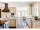 Spacious kitchen with custom cabinets, granite counters, a farmhouse sink, and hardwood flooring overlooking the dining nook at 4041 E Forbes Ct, Greenwood Village, CO 80121
