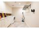 Bright laundry room with white cabinetry, modern appliances, and colorful backsplash at 4041 E Forbes Ct, Greenwood Village, CO 80121