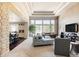Bright living room with tall windows, modern furniture, and an open floor plan adjacent to the kitchen and breakfast nook at 4041 E Forbes Ct, Greenwood Village, CO 80121