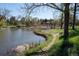 Scenic pond surrounded by lush greenery, a walking path, and a picturesque home in the distance, offering a tranquil retreat at 4041 E Forbes Ct, Greenwood Village, CO 80121