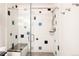 Sleek shower with glass door, built-in bench, and unique tile design at 4041 E Forbes Ct, Greenwood Village, CO 80121