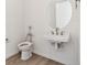 White half-bathroom with a round mirror at 11475 E Briarwood Cir, Centennial, CO 80112