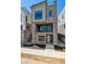 Modern three-story home featuring a brick facade and a second-story balcony at 11475 E Briarwood Cir, Centennial, CO 80112
