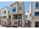 Modern three-story home featuring a brick facade and a second-story balcony at 11475 E Briarwood Cir, Centennial, CO 80112