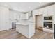 Bright kitchen features white cabinetry, stainless steel appliances, and a center island at 11475 E Briarwood Cir, Centennial, CO 80112