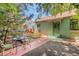 Quaint exterior with an iron table set, garden beds, and unique metal door adding character at 2227 N Gilpin St, Denver, CO 80205
