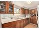 Traditional kitchen with wood cabinets, white appliances, and a window over the sink at 2227 N Gilpin St, Denver, CO 80205