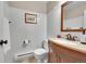 Cozy half bathroom with tiled floors, white walls, and a wooden vanity with a mirror at 1093 Lilac Cir, Broomfield, CO 80020