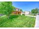 Beautifully landscaped front yard of a two-story home with lush green grass and mature trees at 1093 Lilac Cir, Broomfield, CO 80020