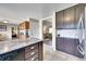 Kitchen with granite countertop island, stainless steel dishwasher, and tiled floors at 1093 Lilac Cir, Broomfield, CO 80020