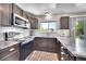 Charming kitchen with stainless steel appliances, subway tile backsplash, and dark wood cabinetry at 1093 Lilac Cir, Broomfield, CO 80020