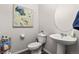 Chic powder room featuring a pedestal sink, a round mirror, and floral wall art at 193 Ambrose St, Erie, CO 80516