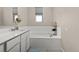 Bright bathroom showcases a soaking tub with tiled surround and a vanity area at 193 Ambrose St, Erie, CO 80516