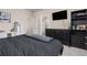 Bedroom showcases a dark bed, dresser with a TV, and an adjoining bathroom at 193 Ambrose St, Erie, CO 80516