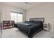 Well-lit bedroom boasts a large window, dark bed, and bookshelf with colorful books at 193 Ambrose St, Erie, CO 80516