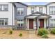 Townhome with a covered porch and stone accents; table and chairs on the front patio at 193 Ambrose St, Erie, CO 80516