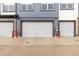 Modern townhouse garages with white doors, gray siding, and brick accents, providing secure parking and storage at 193 Ambrose St, Erie, CO 80516