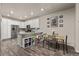 Eat-in kitchen featuring white cabinetry, stainless steel appliances, and wood-look floors at 193 Ambrose St, Erie, CO 80516