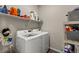 Well-organized laundry room with front load white washer and dryer on wood-look floor at 193 Ambrose St, Erie, CO 80516