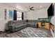 Relaxing living room with an L-shaped couch, mounted TV, ceiling fan, and wood floors at 193 Ambrose St, Erie, CO 80516