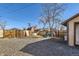 Backyard with gravel, a wooden fence, playset, and the side of the home at 101 2Nd St, Fort Lupton, CO 80621