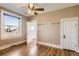 Bedroom featuring wood floors, a ceiling fan, a window, and an adjacent room at 101 2Nd St, Fort Lupton, CO 80621