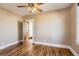 Bedroom featuring hardwood floors, a ceiling fan, a window, and an adjacent room at 101 2Nd St, Fort Lupton, CO 80621