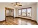 Bright living room featuring hardwood floors, vintage trim details, ceiling fan, and large windows at 101 2Nd St, Fort Lupton, CO 80621