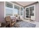 Charming back porch with comfortable seating, a patterned rug, and view from large windows at 7408 Xenophon St, Arvada, CO 80005