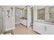 Bright bathroom featuring double vanity, granite counters, modern fixtures, and decorative wall art at 7408 Xenophon St, Arvada, CO 80005