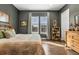 Well-lit bedroom with wood floors, warm colors, and ample natural light at 7408 Xenophon St, Arvada, CO 80005