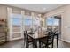 Dining area with large windows, hardwood floors, and sliding glass door leading to the patio at 7408 Xenophon St, Arvada, CO 80005